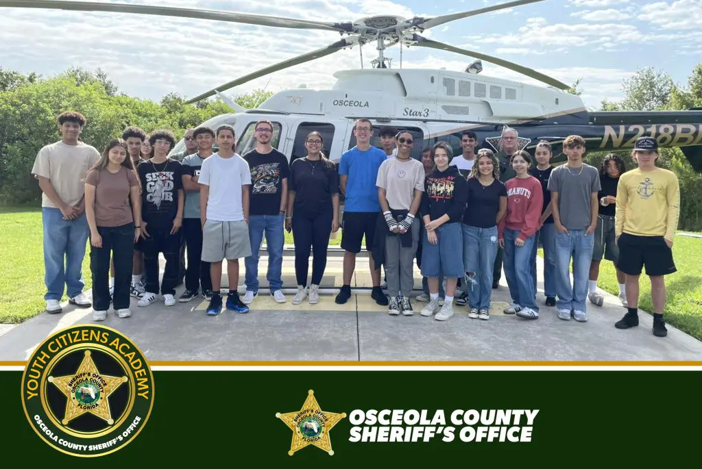 Teen participants from the Youth Citizen’s Academy standing in front of a Sheriff’s Office helicopter.